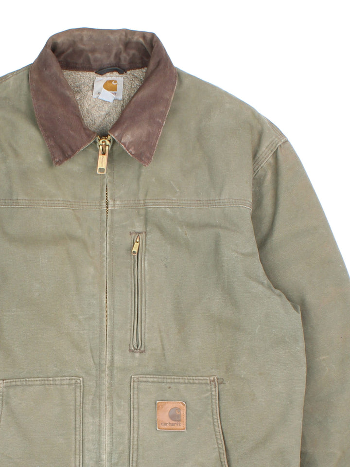 Vintage Carhartt Arctic Jacket in a khaki green colourway with a brown collar. Zips up and has multiple pockets, insulated with a sherpa lining, and has the logo embroidered on the front.