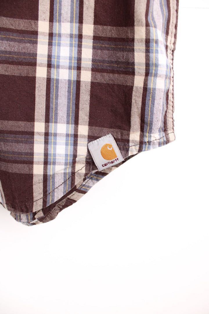 Carhartt Short Sleeve Shirt in a brown, white and blue plaid colourway, button up with a chest pocket, and has the logo embroidered on the front. 