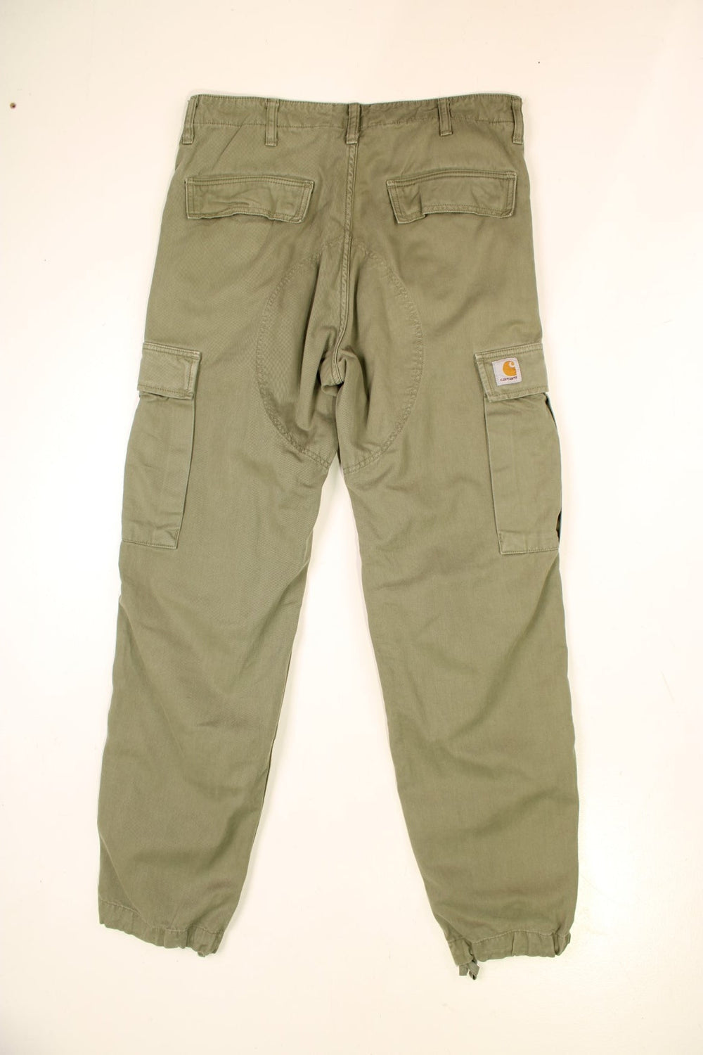 Carhartt Cargo Trousers in a green colourway with multiple pockets and the logo embroidered on the back.