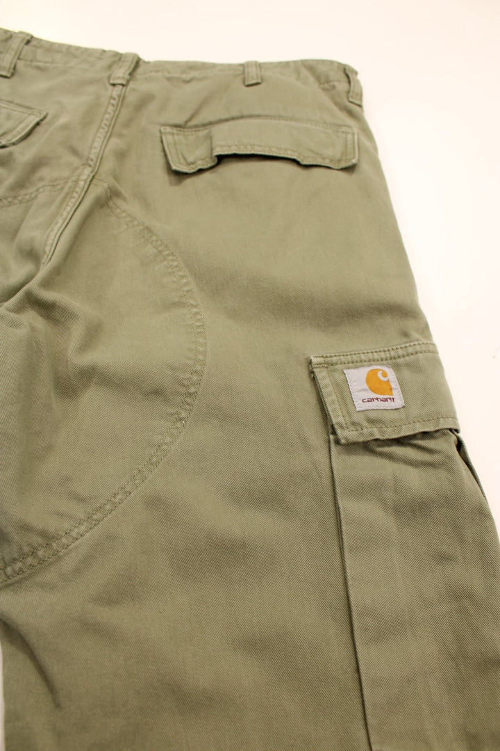 Carhartt Cargo Trousers in a green colourway with multiple pockets and the logo embroidered on the back.