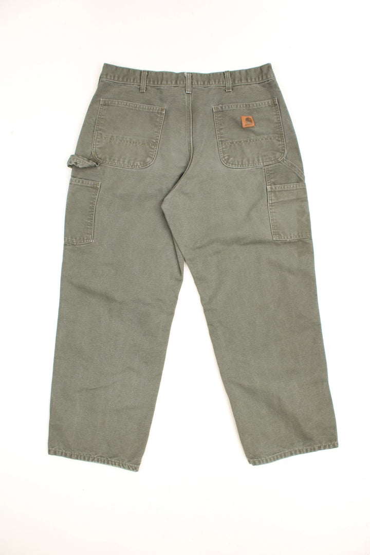 Carhartt Carpenter Jeans in a khaki green colourway, has multiple pockets and the logo embroidered on the back. 