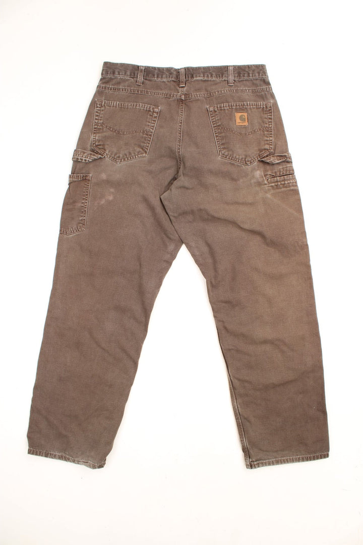 Carhartt Carpenter Jeans in a faded brown colourway, has multiple pockets and the logo embroidered on the back. 