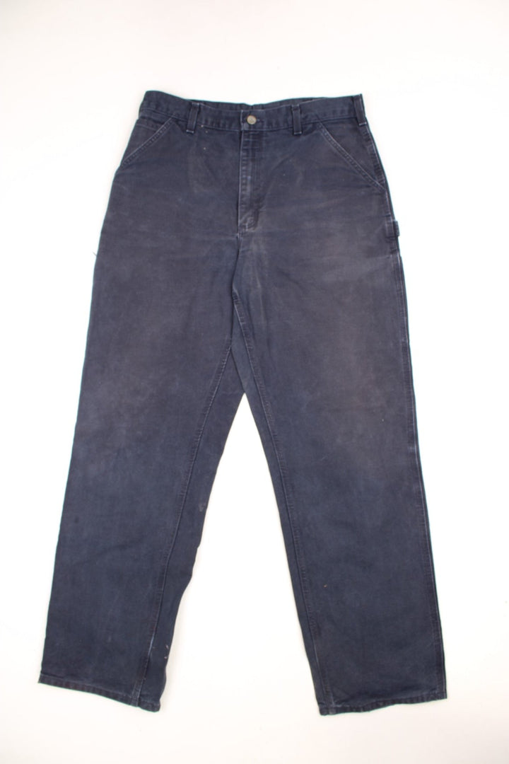 Carhartt black carpenter jeans with front, back and side pockets, a hammer loop, and a logo patch on the back pocket. 