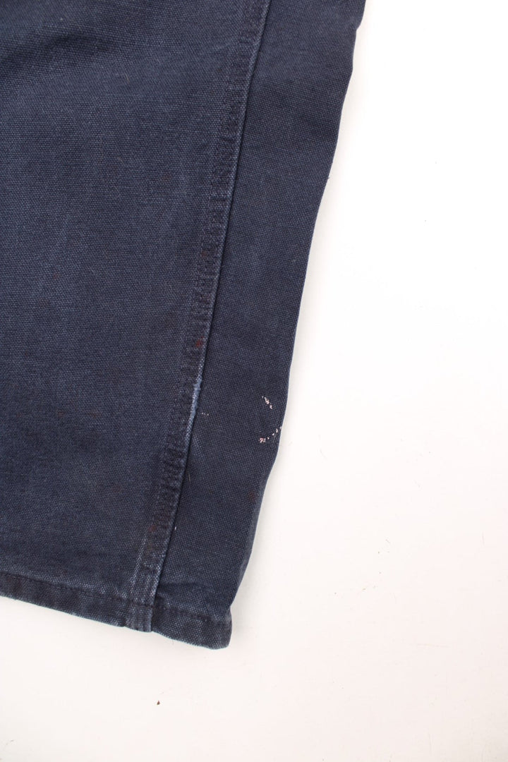 Carhartt black carpenter jeans with front, back and side pockets, a hammer loop, and a logo patch on the back pocket. 