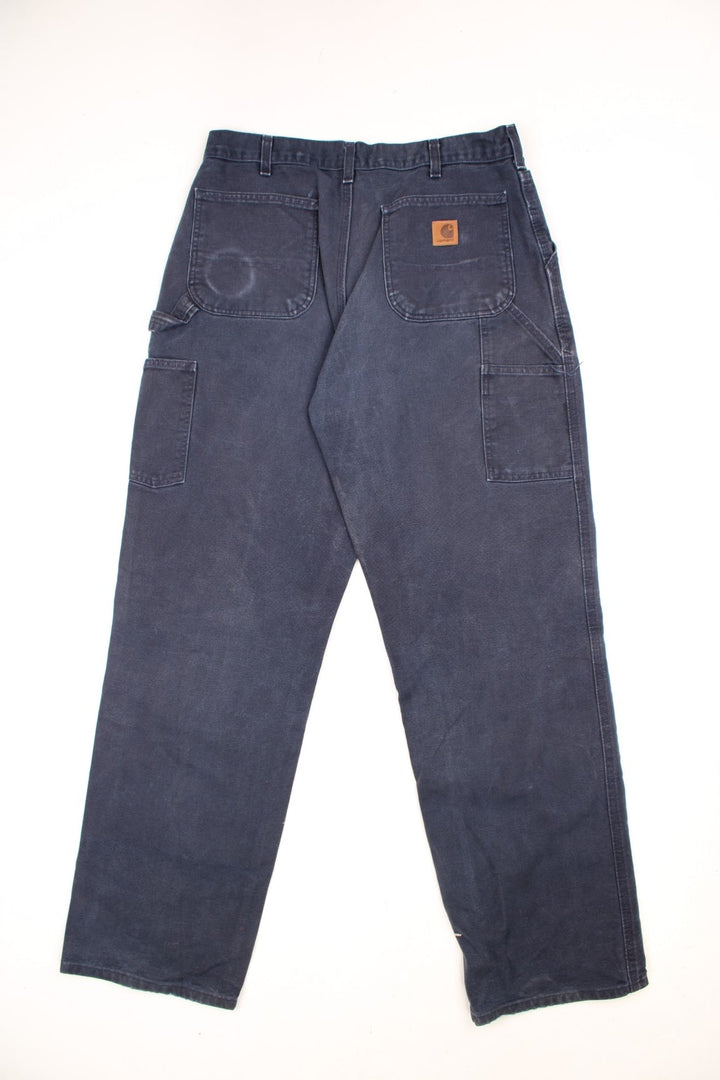 Carhartt black carpenter jeans with front, back and side pockets, a hammer loop, and a logo patch on the back pocket. 