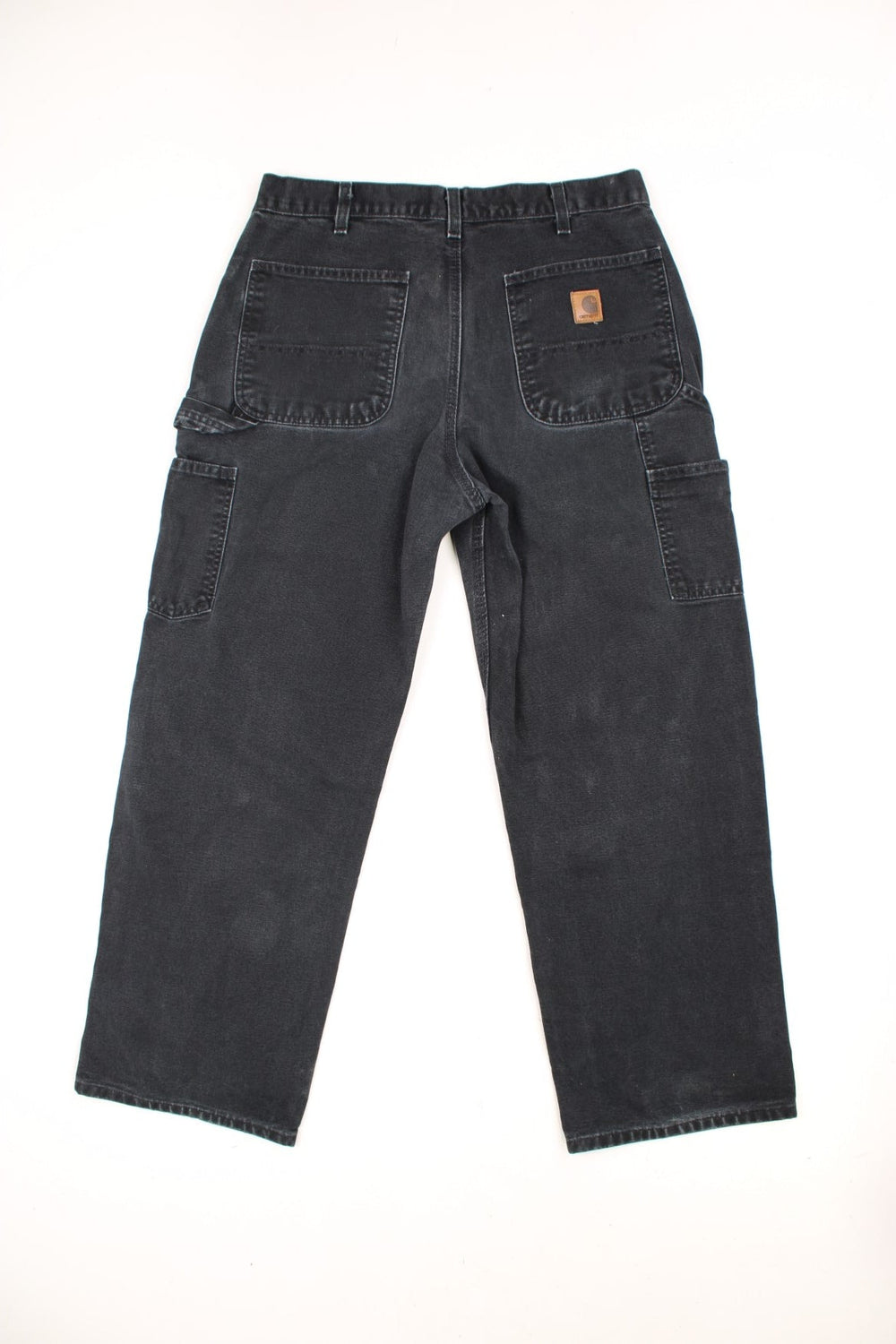 Carhartt black carpenter jeans with front, back and side pockets, a hammer loop, and a logo patch on the back pocket. 