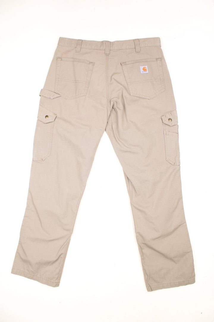 Carhartt tan double knee trousers with a hammer loop, front, back and side pockets and a logo patch on the back pocket. 