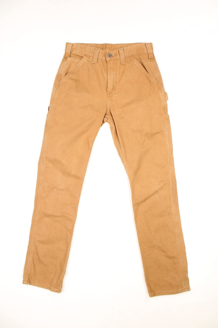 Carhartt tan carpenter jeans with a hammer loop, front, back and side pockets and a logo patch on the back pocket. 