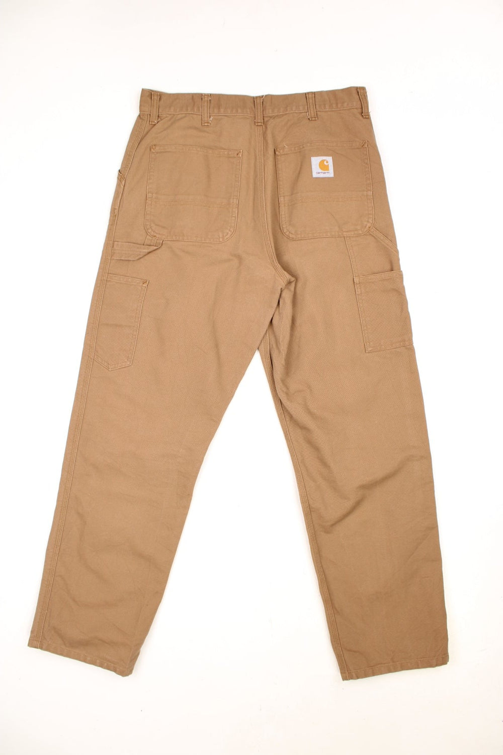 Carhartt tan carpenter jeans with a hammer loop, front, back and side pockets and a logo patch on the back pocket. 