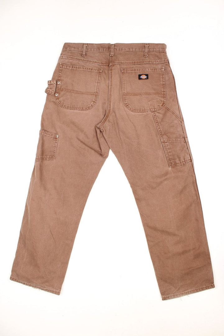 Dickies brown carpenter jeans with a hammer loop, front, back and side pockets and a logo patch on the back pocket. 