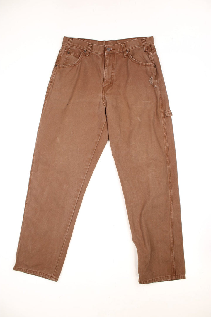 Dickies brown carpenter jeans with a hammer loop, front, back and side pockets and a logo patch on the back pocket. 