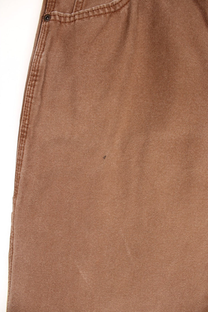 Dickies tan carpenter jeans with a hammer loop, front, back and side pockets and a logo patch on the back pocket. 