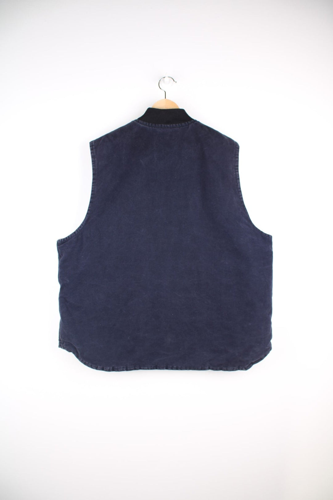 Carhartt Gilet Jacket in an indigo blue colourway. The gilet has two front pockets, a metal zippper to close, and the Carhartt leather patch stitched onto the pocket. 