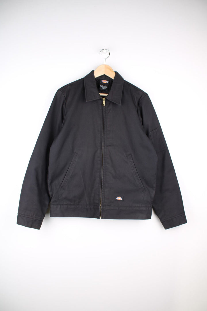 Dickies Eisenhower Workwear Jacket in a black colourway. The jacket two jetted pockets on the front, a silver zip to close and a small patch pocket on the left sleeve. 