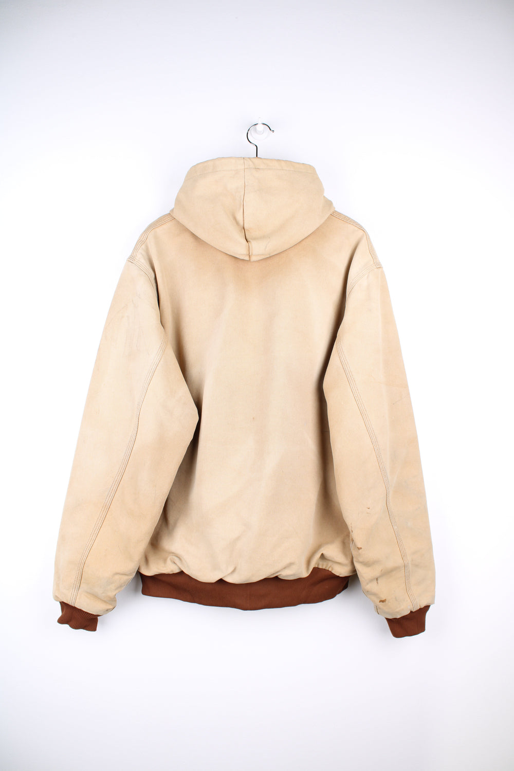 Vintage Carhartt Active Hooded Jacket in a tan colourway. The jacket has two front pockets, a gold zip to close and the Carhartt logo stitched onto the front. 