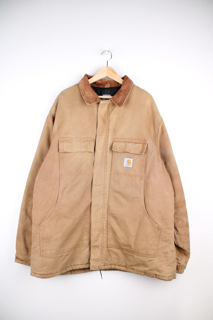 Vintage Carhartt Arctic Jacket in a tan colourway. The jacket has 2 velcro pockets, and two hand warmer pockets. It also has a corduroy collar and has a quilted lining.