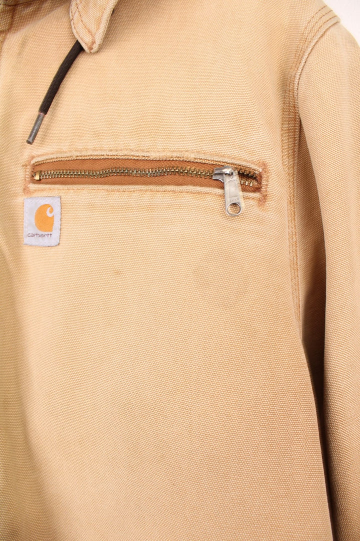 Carhartt Wildwood Sherpa Jacket in tan with zip closure, multiple pockets, sherpa lining, detachable hood and the logo embroidered on the front. 