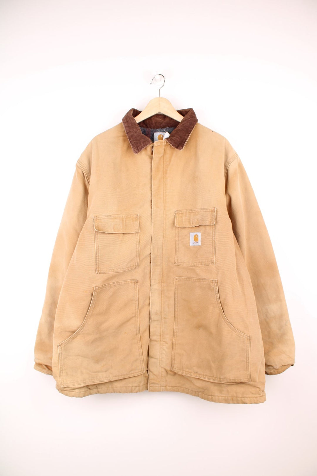 Carhartt Detroit jacket in tan. Blanket lined with a brown corduroy collar, zip and velcro closure, four pockets with a logo patch on the upper left. 