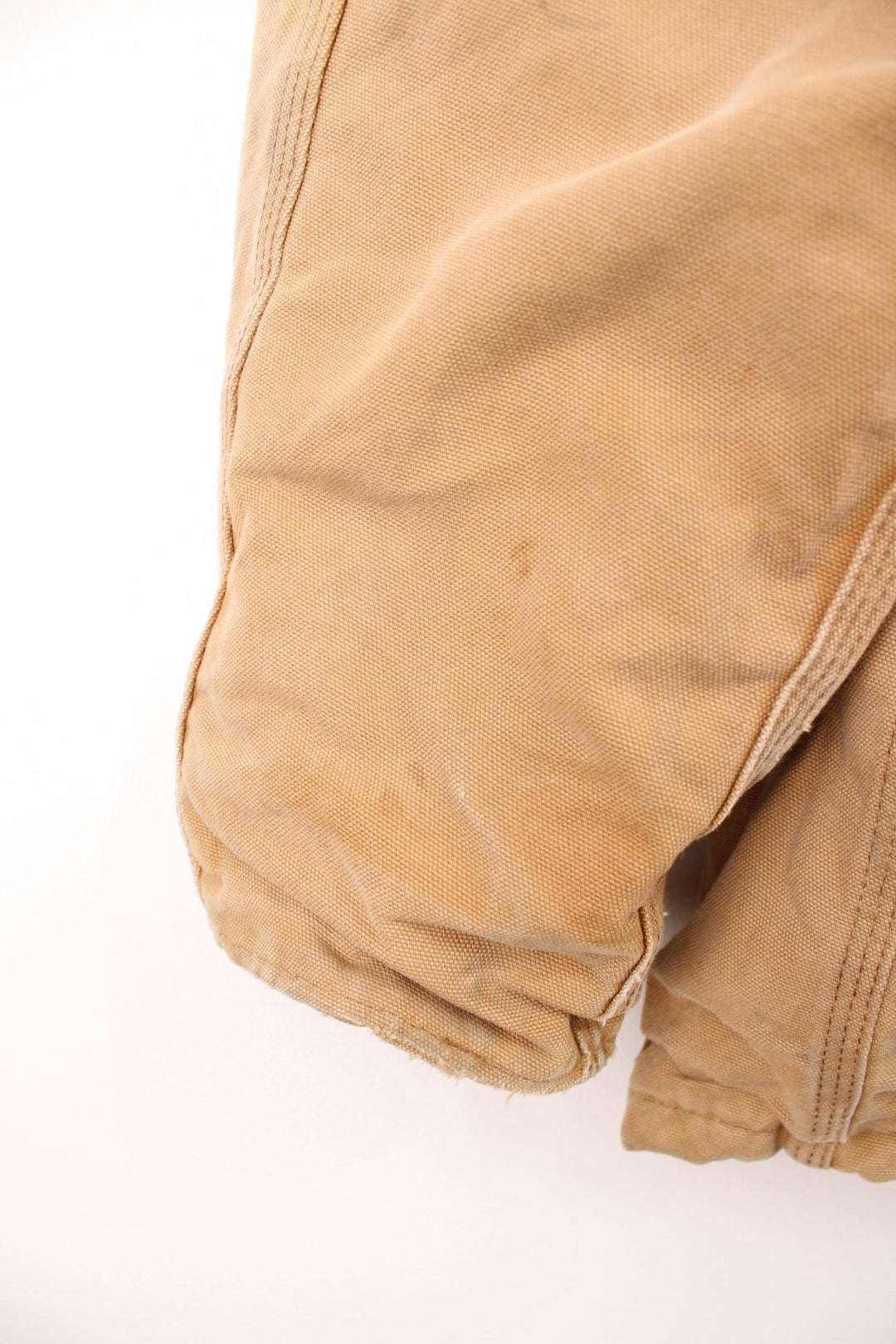 Carhartt Detroit jacket in tan. Blanket lined with a brown corduroy collar, zip and velcro closure, four pockets with a logo patch on the upper left. 