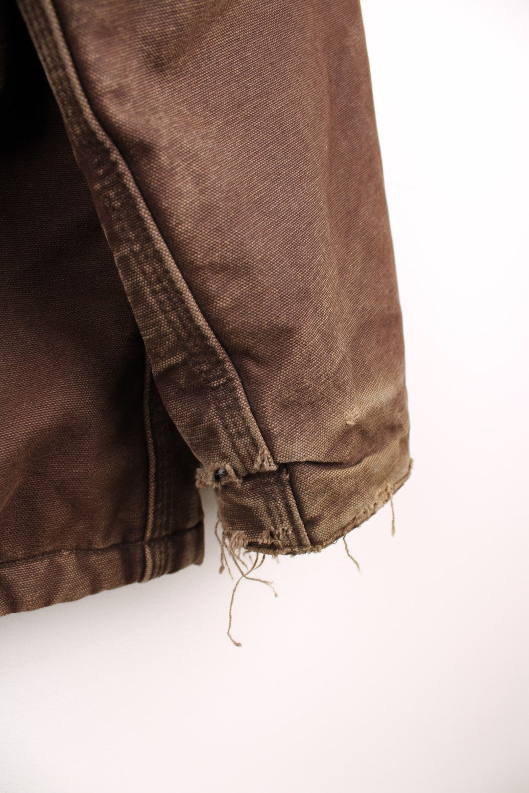 Carhartt Arctic jacket in brown. Quilt lined, with a dark brown corduroy collar,zip and velcro closure, four pockets and a leather logo patch on the upper left.  