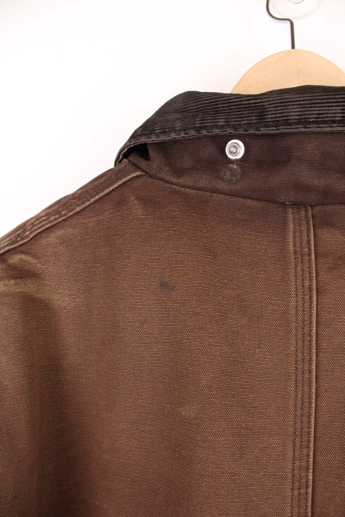 Carhartt Arctic jacket in brown. Quilt lined, with a dark brown corduroy collar,zip and velcro closure, four pockets and a leather logo patch on the upper left.  