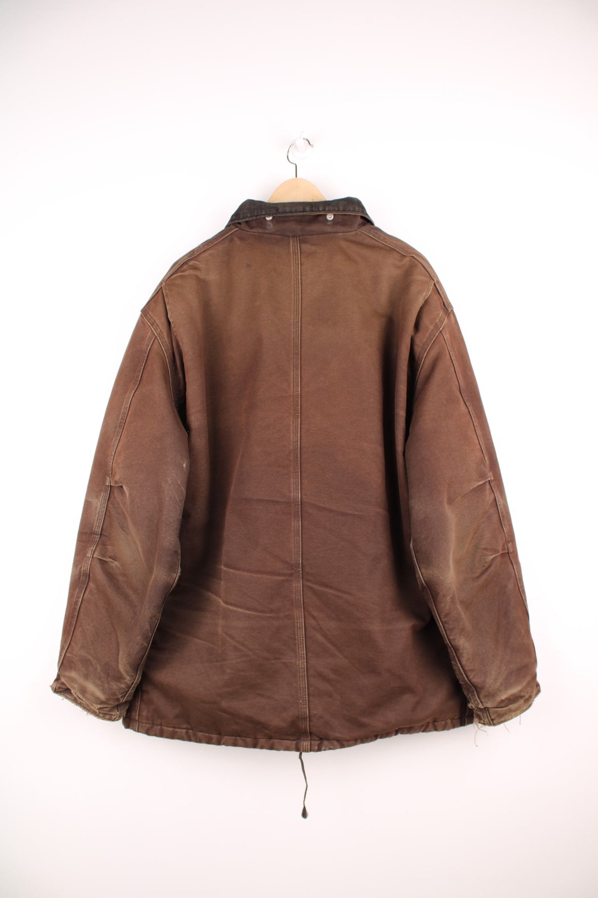 Carhartt Arctic jacket in brown. Quilt lined, with a dark brown corduroy collar,zip and velcro closure, four pockets and a leather logo patch on the upper left.  