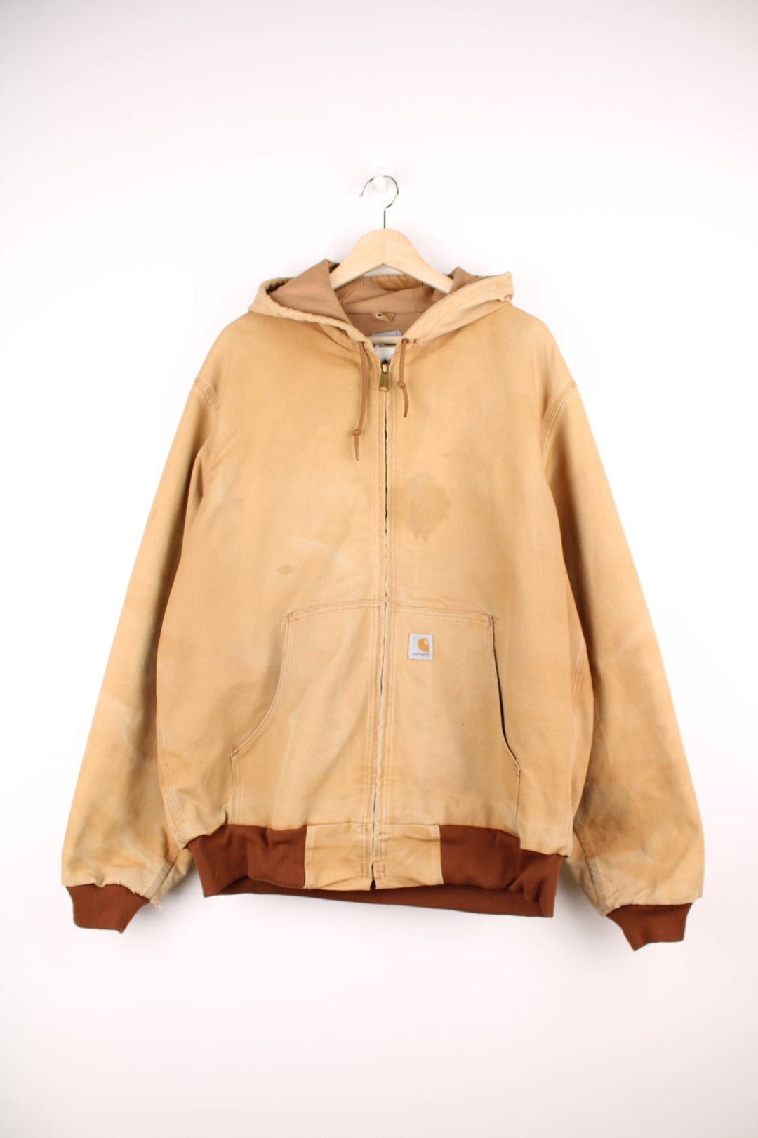 Carhartt Active jacket in tan with zip closure, brown trim and cuffs, an adjustable hood, double side pockets and a logo patch on the lower left. 