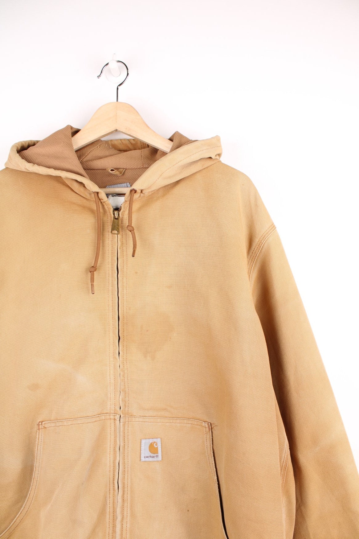 Carhartt Active jacket in tan with zip closure, brown trim and cuffs, an adjustable hood, double side pockets and a logo patch on the lower left. 