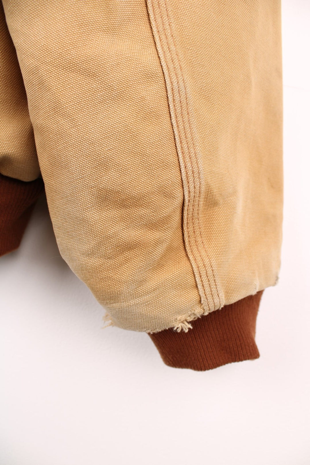 Carhartt Active jacket in tan with zip closure, brown trim and cuffs, an adjustable hood, double side pockets and a logo patch on the lower left. 