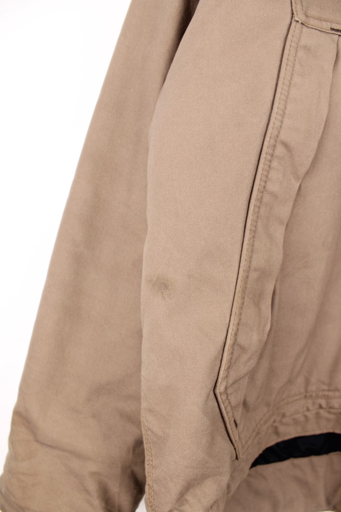 Carhartt work jacket in tan with four pockets, zip closure, a Carhartt logo patch on the upper left and a &