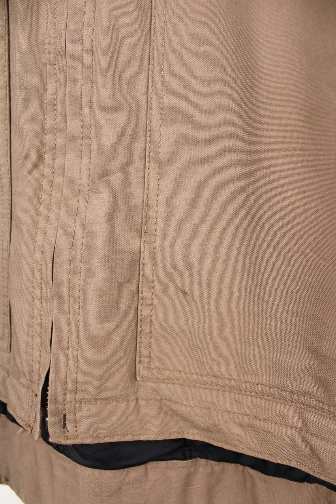 Carhartt work jacket in tan with four pockets, zip closure, a Carhartt logo patch on the upper left and a &