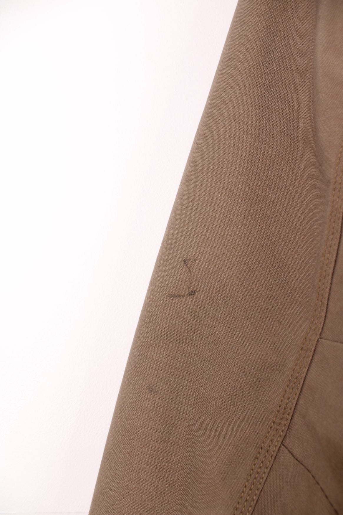 Carhartt work jacket in tan with four pockets, zip closure, a Carhartt logo patch on the upper left and a &