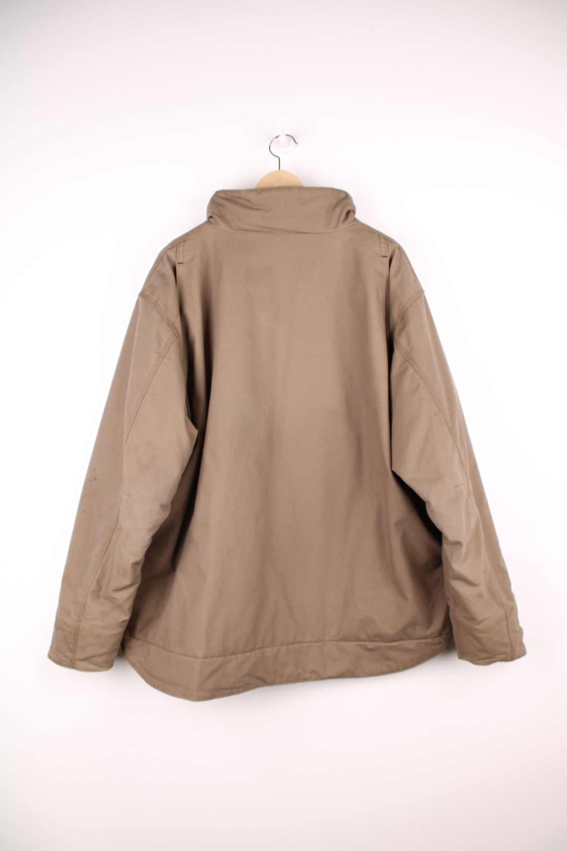 Carhartt work jacket in tan with four pockets, zip closure, a Carhartt logo patch on the upper left and a &