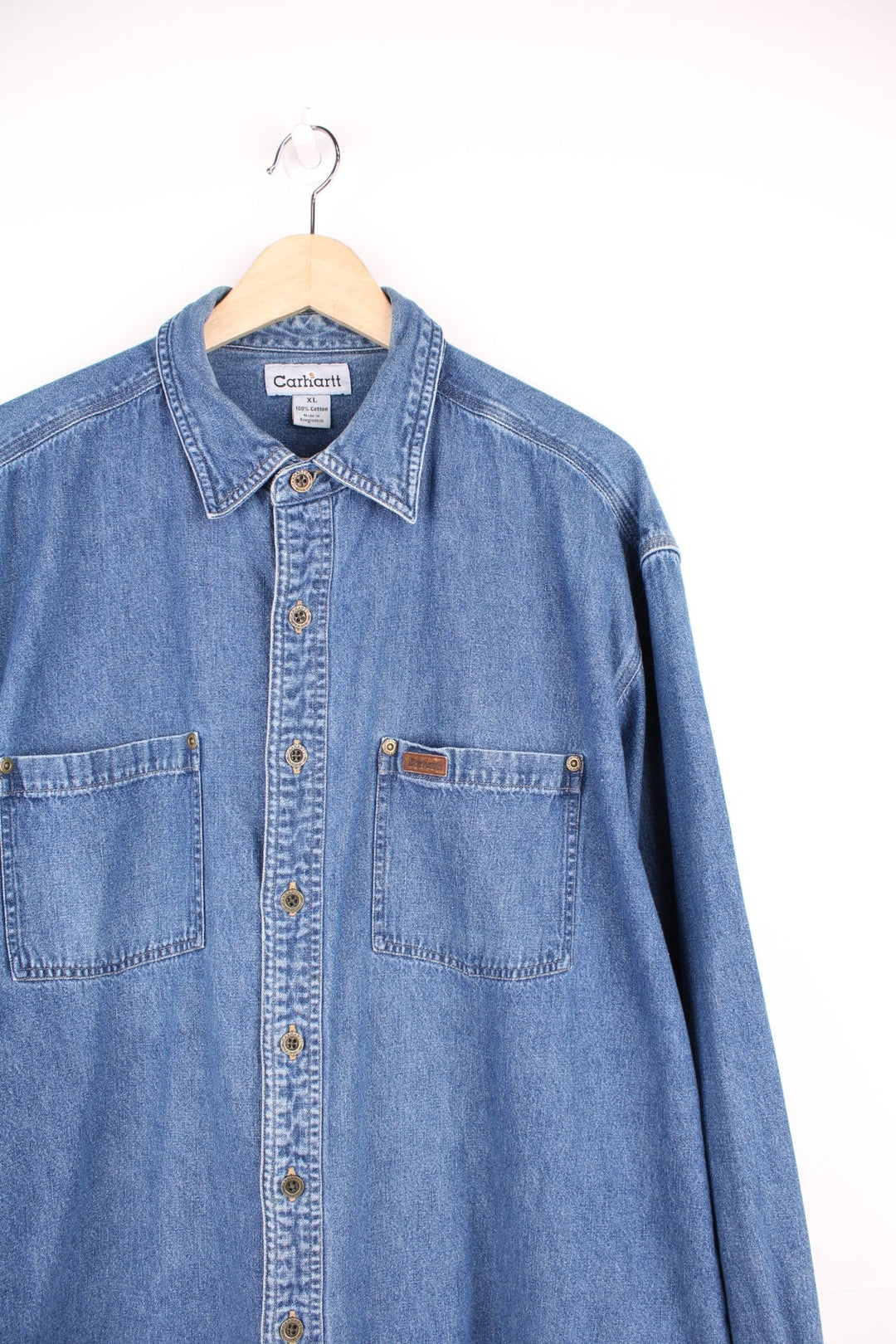 Carhartt button through denim blue denim shirt. Features chest pockets and embroidered leather logo.