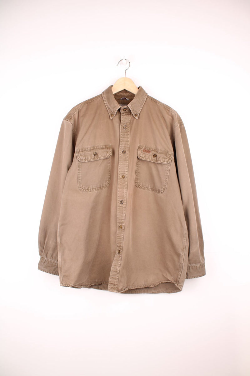 Carhartt brown canvas shirt. Features chest pockets and embroidered leather logo.