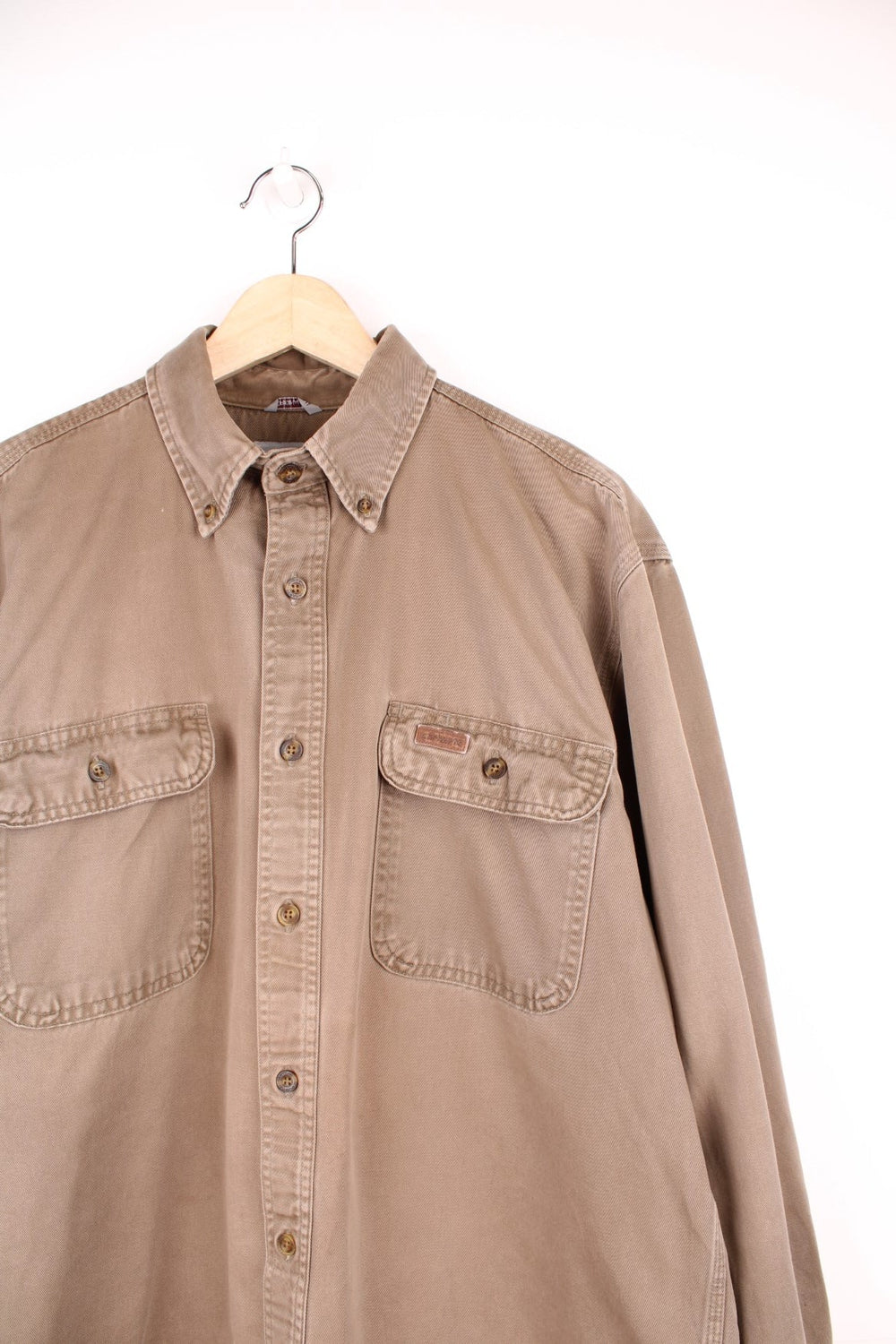 Carhartt brown canvas shirt. Features chest pockets and embroidered leather logo.