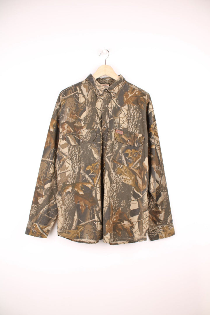 Woolrich Realtree Hardwoods Camouflage button through shirt. Features chest pockets and embroidered leather logo.