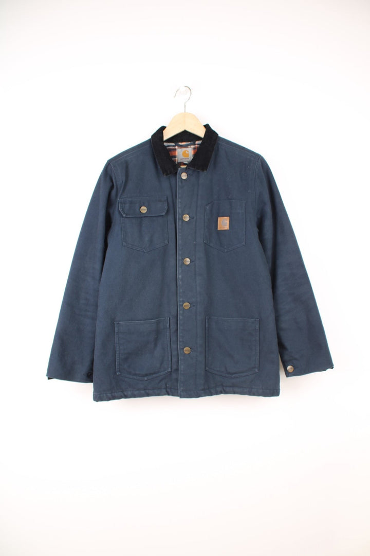 Carhartt Workwear Jacket in a blue colourway with a black corduroy collar, button up with multiple pockets and has the logo embroidered on the front. 