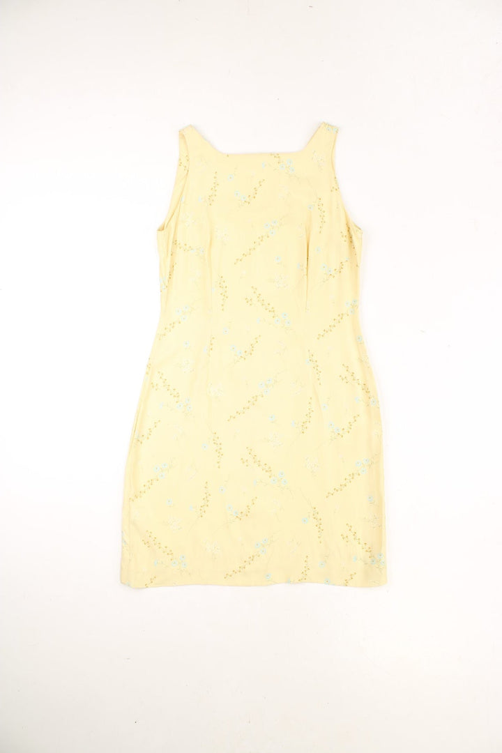 Vintage sunshine yellow summer dress with a ditsy floral pattern in white and blue, with front and back pleats and zip closure. 