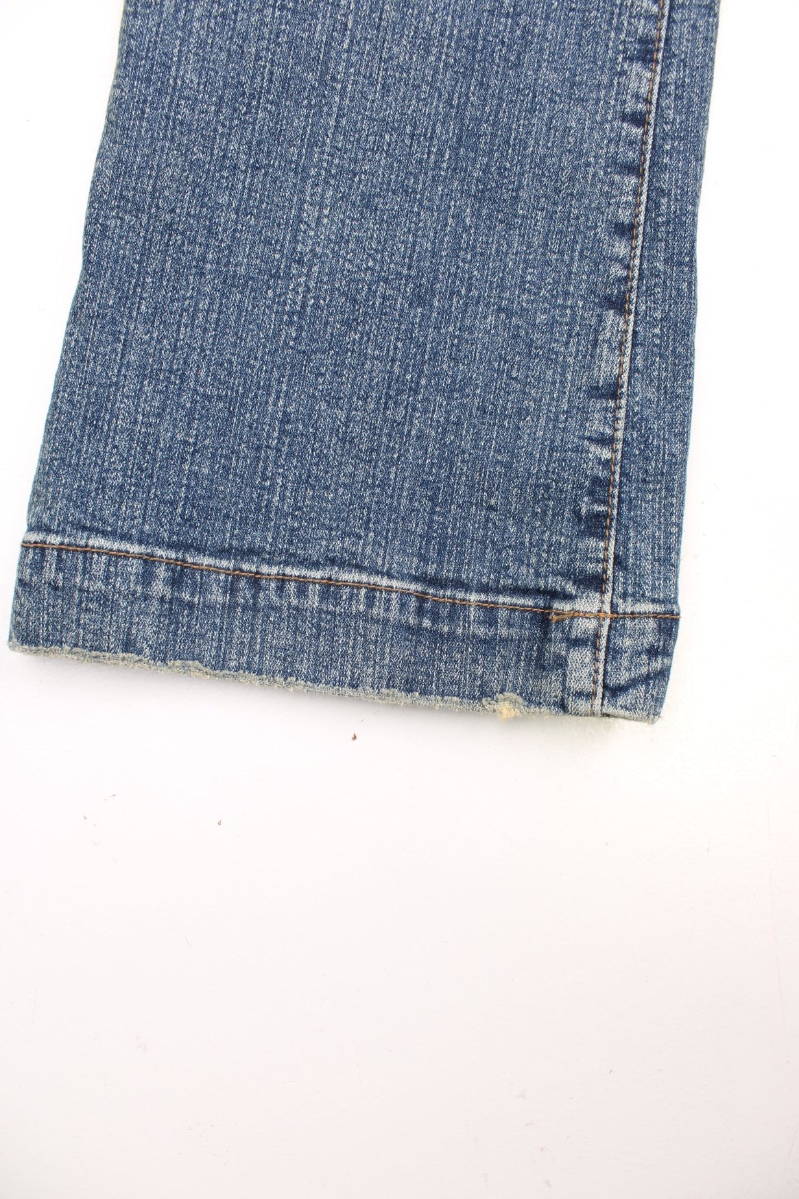 Y2K low rise bootcut jeans with four pockets and a buttoned belt detail.