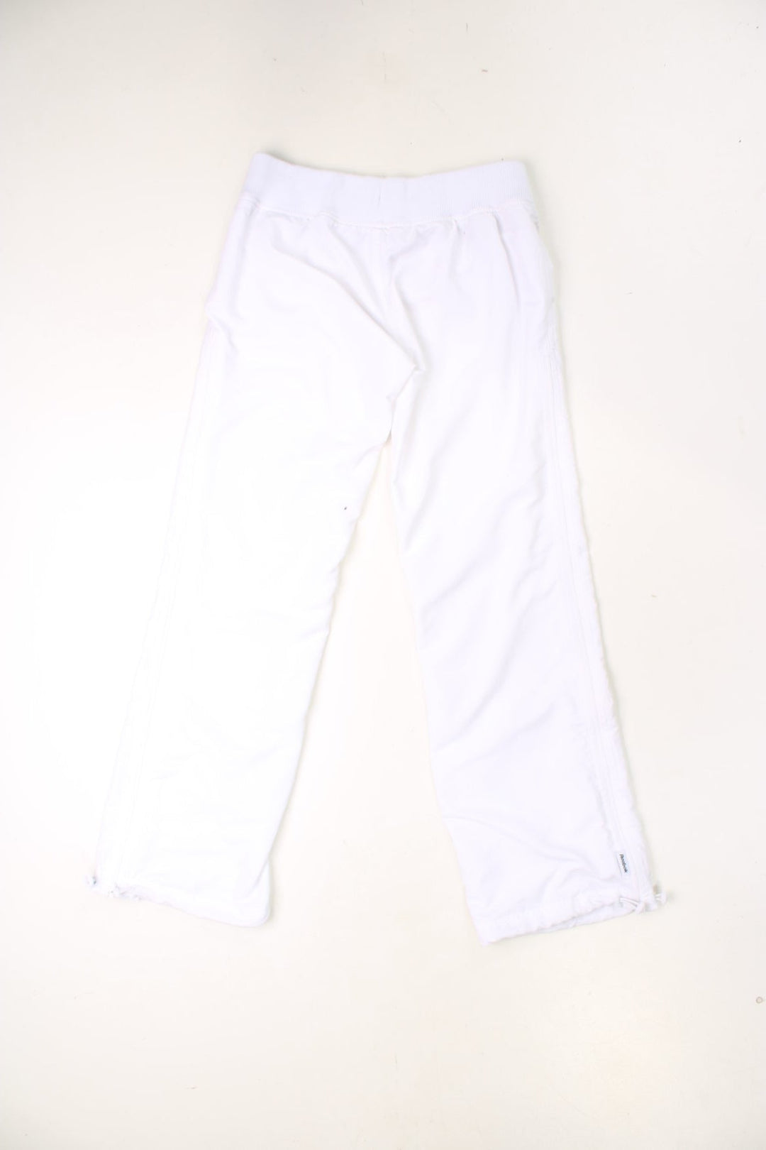 Vintage Reebok trousers with elasticated waistband and drawstring. Features embroidered logo, zips up each leg and toggle pulls on each cuff. 