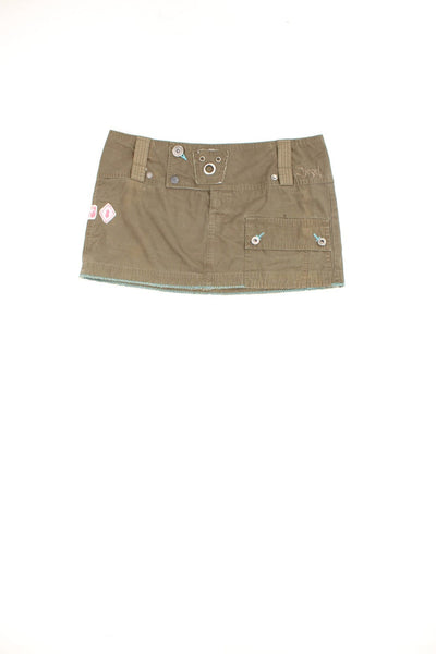 Vintage Diesel low rise cargo style mini skirt in khaki green. Features graphic badge patches, button fastening and pocket.