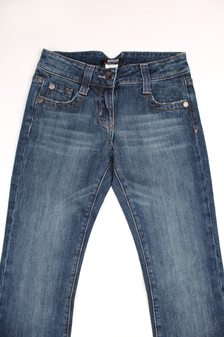 Y2K Morgan Jeans in a dark blue denim wash, low waisted with flares, has multiple pockets and 'M' embroidered patterns on the back. 