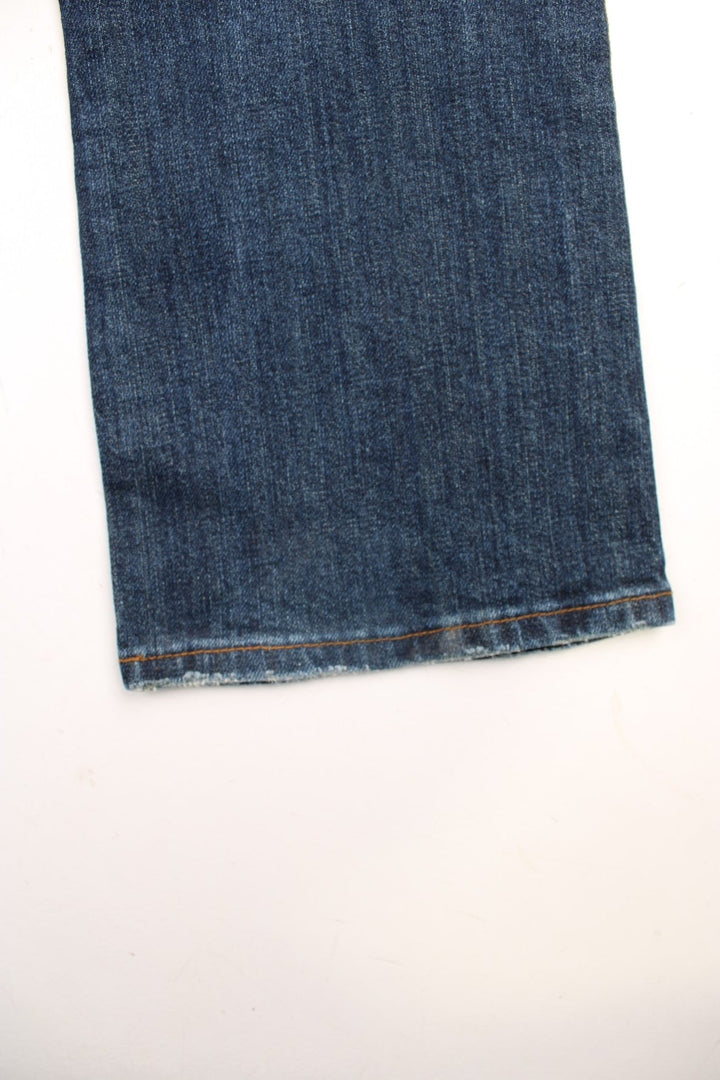 Y2K Morgan Jeans in a dark blue denim wash, low waisted with flares, has multiple pockets and 'M' embroidered patterns on the back. 