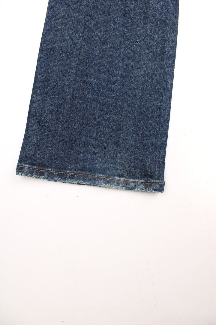 Y2K Morgan Jeans in a dark blue denim wash, low waisted with flares, has multiple pockets and 'M' embroidered patterns on the back. 