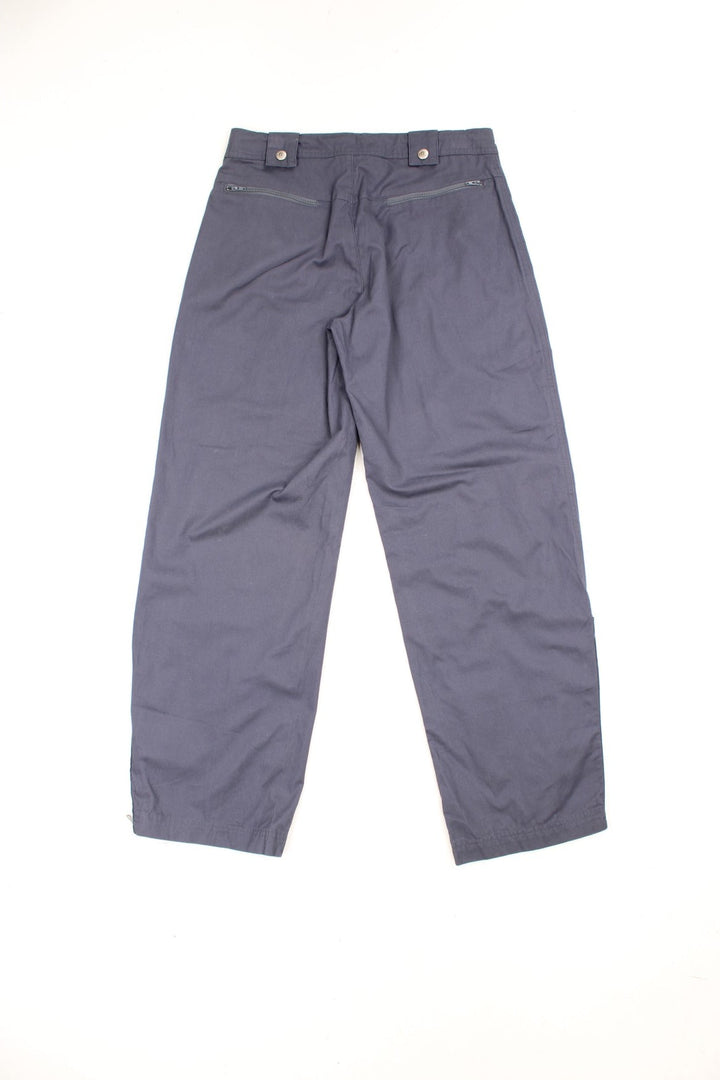 Grey Reebok cotton trousers with zip and popper fastening, zip pockets, zips up both legs and embroidered spell out logo. 