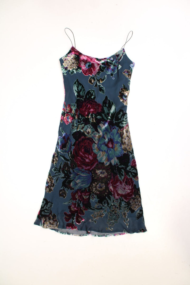 Y2K velvet midi dress by East in dark blue and purple with thin straps and a large dark floral pattern.  