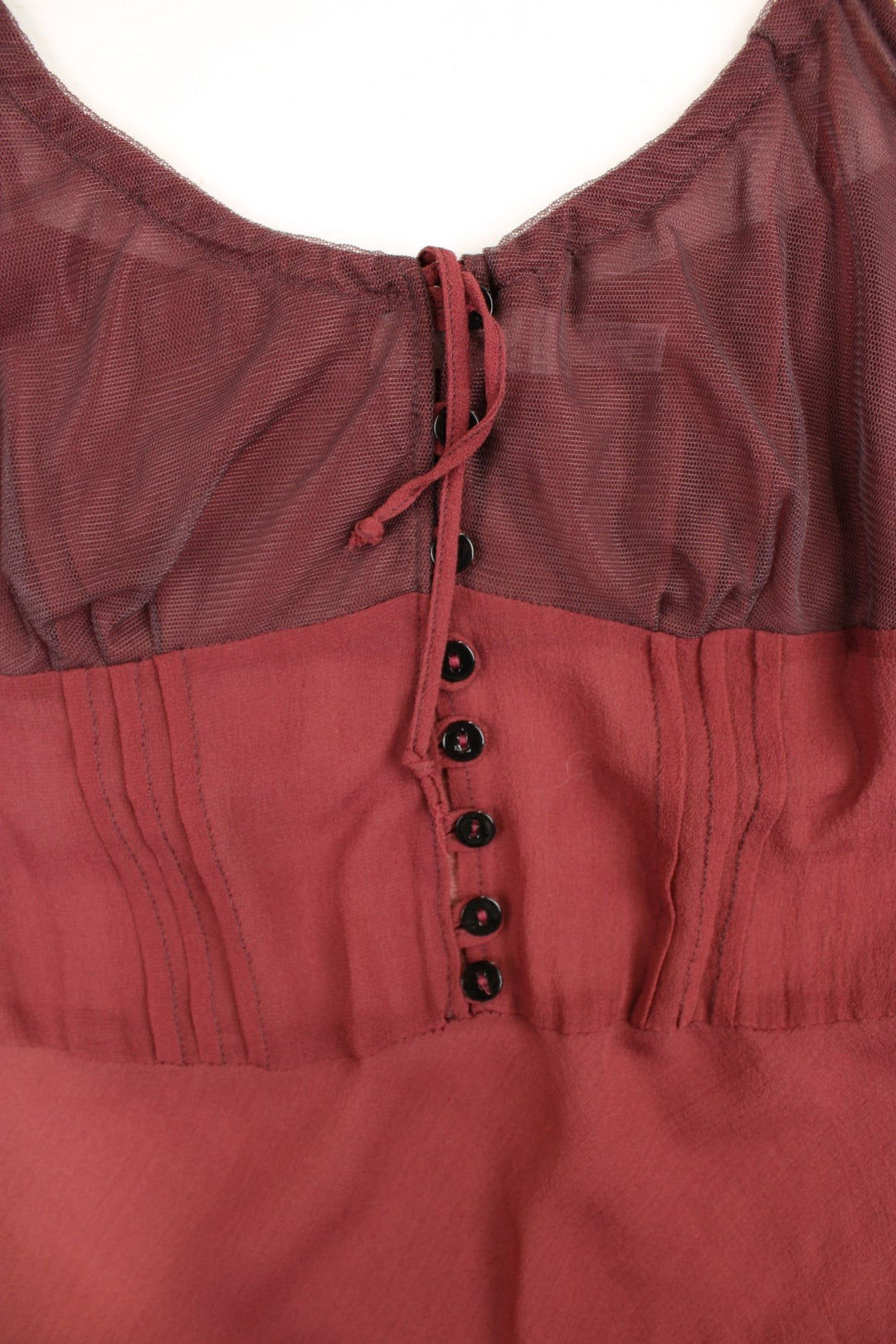 Y2K sheer strappy slip dress in red with buttons, adjustable straps, and a distressed ruffled hem .