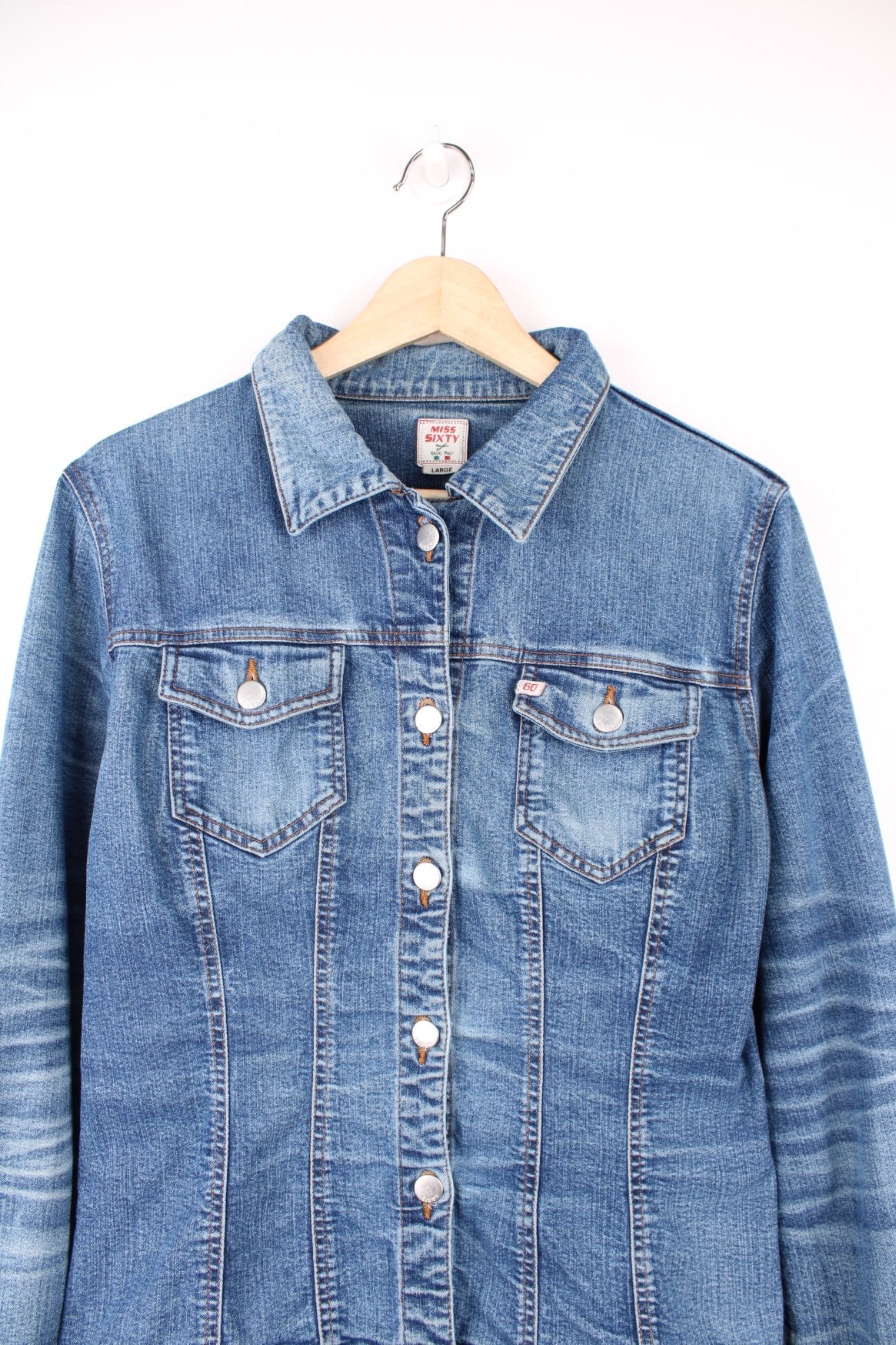 Blue denim jacket by Miss Sixty with button closure and two flap pockets. With small Miss Sixty tags on the chest and lower back hem. 