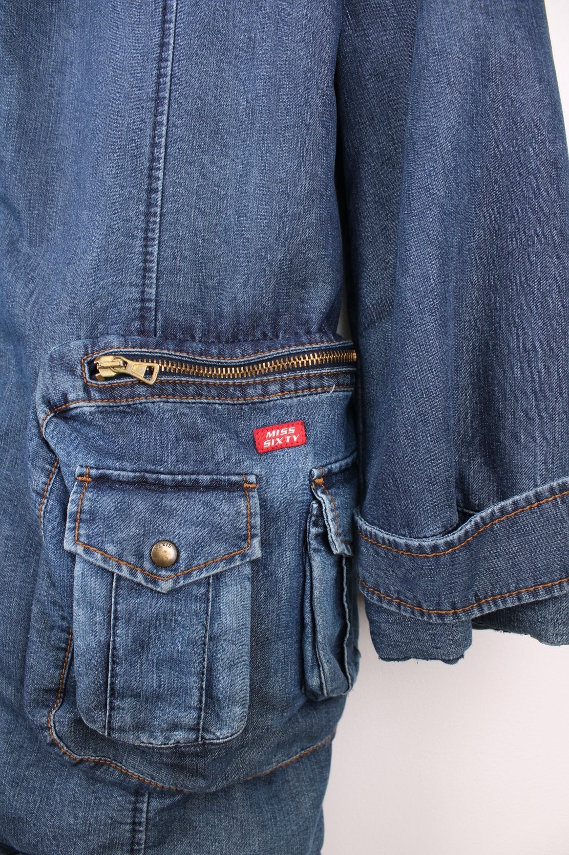 Blue Miss Sixty denim parka with faux fur lined hood, zip closure, eight zip, snap and buckle pockets. 